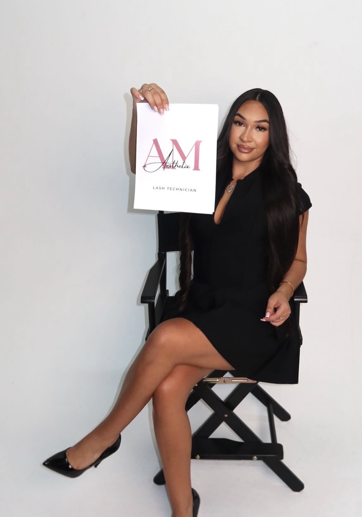 Angie holding an AM Aesthetix lash technician sign